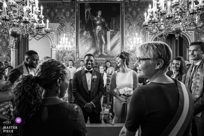 Photo by: <a href="https://www.wpja.com/contests/2019-v06/best-wedding-photographers/2493736">Henri Deroche - Orléans </a> The bride laughs at a joke as she and her groom stand at the altar in Orleans in this black and white photo by a France wedding photographer.
