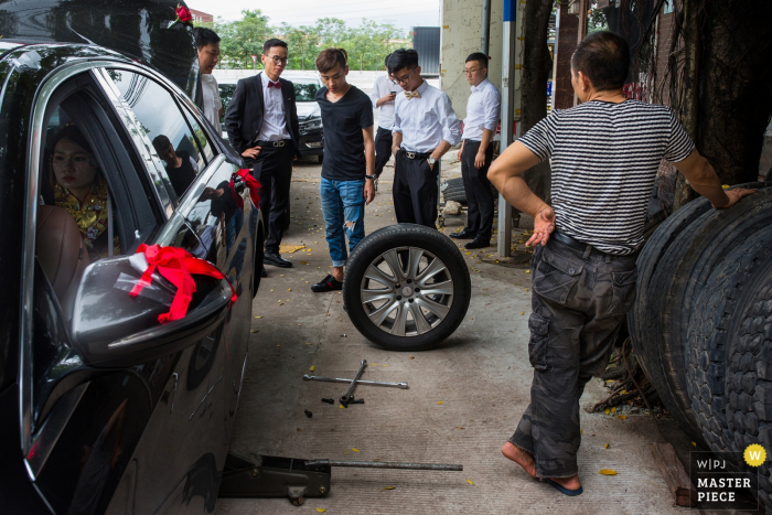 Zdjęcie: <a href="https://www.wpja.com/contests/2019-v06-photography-competition/best-wedding-photographers/2493826"> Max Ming - Huizhou </a> Groomsmen biorą samochód do mechanika, aby zmienić oponę na tym zdjęciu zrobionym przez wielokrotnie nagradzanego fotografa ślubnego Huizhou w Chinach.