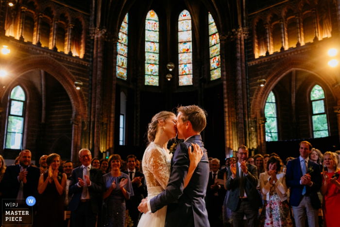 La fotografia della sposa e lo sposo baciano durante la cerimonia a Vondelkerk Amsterdam