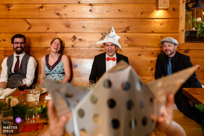 Photo by: <a href="https://www.wpja.com/contests/2019-v06/best-wedding-photographers/2494591">Esther Gibbons - Montreal Quebec</a> Laurentides, Quebec - Chalet Wedding Photo of a couple looking at each other with Japanese paper wedding hats