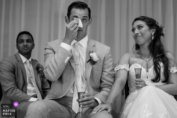 Foto di: <a href="https://www.wpja.com/contests/2019-v06-photography-competition/best-wedding-photographers/2494586"> Shaun Baker - San Diego California </a> Scripps Seaside Forum- La Jolla, California. | La reazione degli sposi da un brindisi dato dal suo testimone in questa foto di matrimonio di S.C.