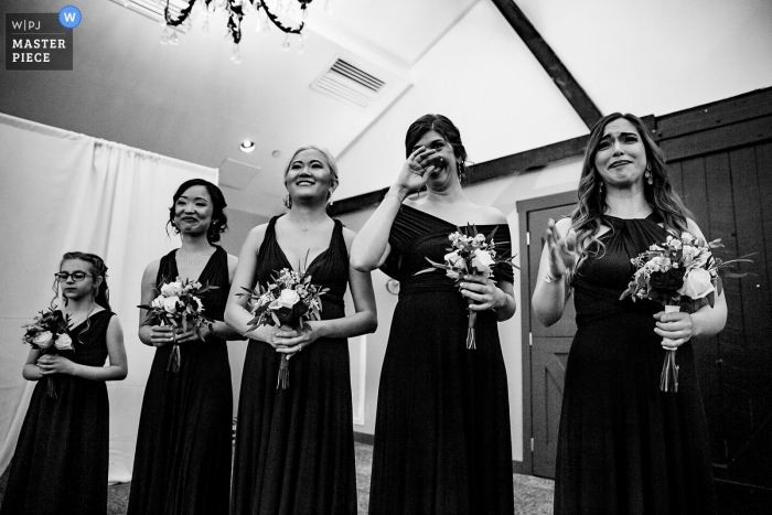 Foto von: <a href="https://www.wpja.com/contests/2019-v06/best-wedding-photographers/2495011"> Miguel Gonzalez - Abington Pennsylvania </a> Normandie Bauernhöfe Hochzeitsfeier Fotografie | Brautjungfern, welche die Braut aufpassen, den Gang herunter zu kommen.