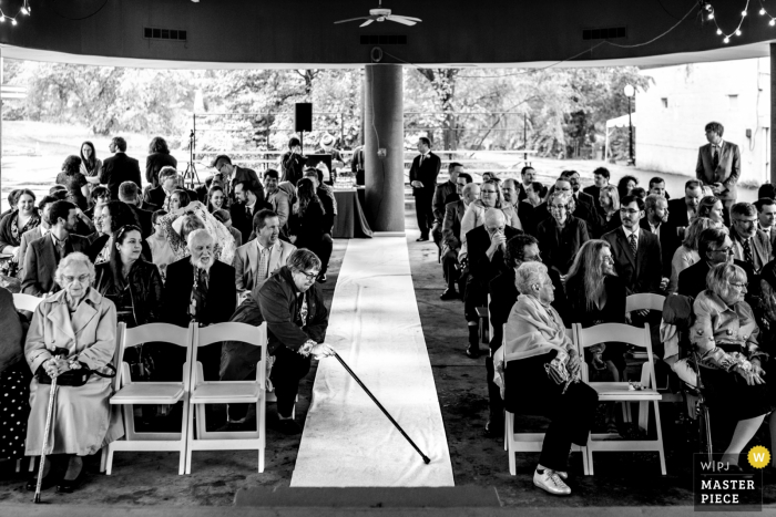 Foto di: <a href="https://www.wpja.com/contests/2019-v06/best-wedding-photographers/2495396"> Johnny Shryock - Arlington Virginia </a> Glen Echo Park, Maryland Wedding Ceremony Fotografia di un ospite che raddrizza il corridore della navata della sposa