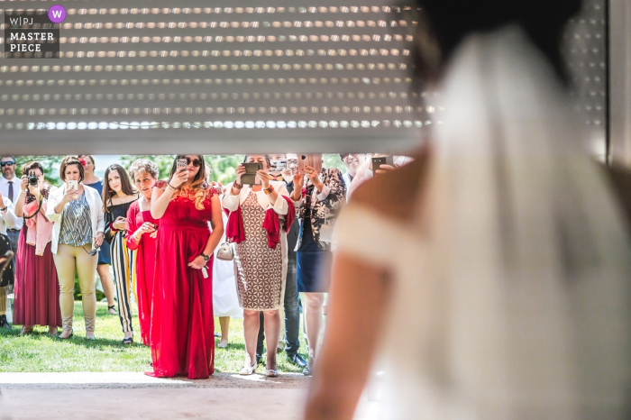 Photo by: <a href="https://www.wpja.com/contests/2019-v07/best-wedding-photographers/2498661">Franck Petit - Serignac sur Garonne </a> Chateau de Malliac wedding photo of bride revealing dress as door rolls up