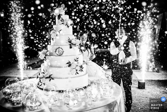 Foto por: <a href="https://www.wpja.com/contests/2019-v07/best-wedding-photographers/2499116"> Stefano Ferrier - Paderno Dugnano Milano </a> Antico borgo della rocca, Rocca Susella, PV, Italia Fotógrafo: "El corte de la torta, el novio sacudió el prosecco antes de abrirlo, tuve que limpiar todas mis lentes y mi equipo pero obtuve la imagen"