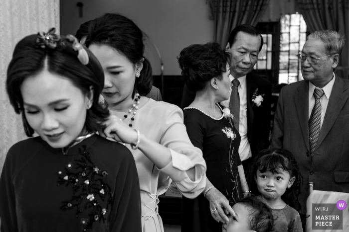 Foto von: <a href="https://www.wpja.com/contests/2019-v07/best-wedding-photographers/2502101"> Jacob Gordon - Ho Chi Minh </a> Die Familie hat einen schönen Moment zusammen, als sie sich auf die Zeremonie in Tay Ninh in diesem schwarz-weißen Hochzeitsfoto vorbereiten, das von einem Fotografen aus Ho Chi Minh, Vietnam, verfasst wurde.