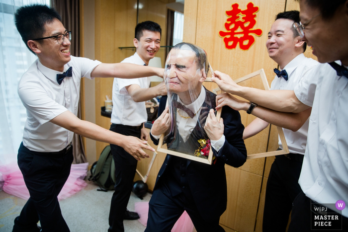 Photo by: <a href="https://www.wpja.com/contests/2019-v07/best-wedding-photographers/2502201">Xin Liu - Fuzhou </a> Lijiang Hotel Fujian/Fuzhou Wedding Day Photography - The groom is playing games at present.