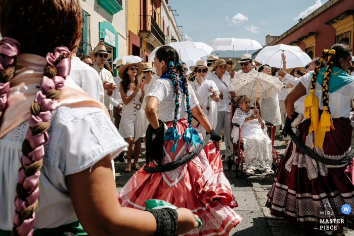 Wedding Photography in the streets of Museo Belber Jiménez Oaxaca | Grandmother at the wedding calenda framed in the Chinas Oaxaqueñas 