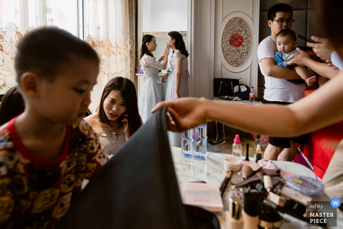 Photo by: <a href="https://www.wpja.com/contests/2019-v07/best-wedding-photographers/2505591">Kai Xiao - Sanming </a> The room is full of people getting themselves ready for the ceremony in this award-winning image composed by a Sanming, China wedding photographer.