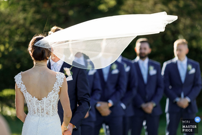 Foto: <a href="https://www.wpja.com/contests/2019-v07/best-wedding-photographers/2505756"> Alex Paul - Boston, Massachusetts </a> Ocean Edge Resort, Brewster, MA Hochzeitsfoto des Brautschleiers, der draußen im Wind weht. RI, VT, MA, NH, CT und New England Hochzeitsfotografie.