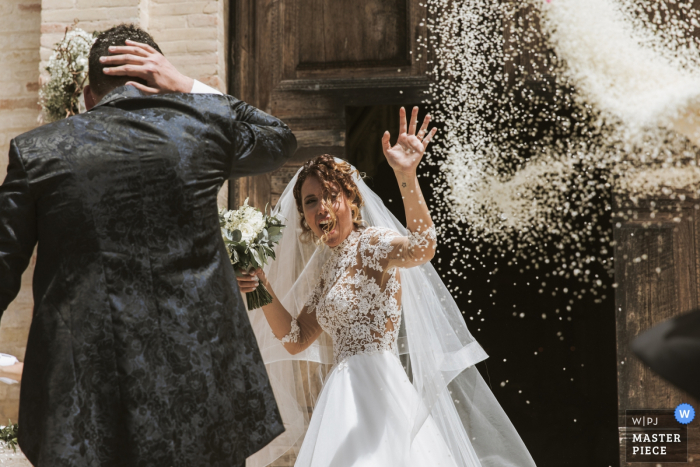 Foto door: <a href="https://www.wpja.com/contests/2019-v07/best-wedding-fotografen/2506181"> Sabrina Vinci - Civitanova Marche Macerata </a> Chiesa Santa Croce Mogliano-foto van de rijst die bij bruid en bruidegom na kerkceremonie werpen
