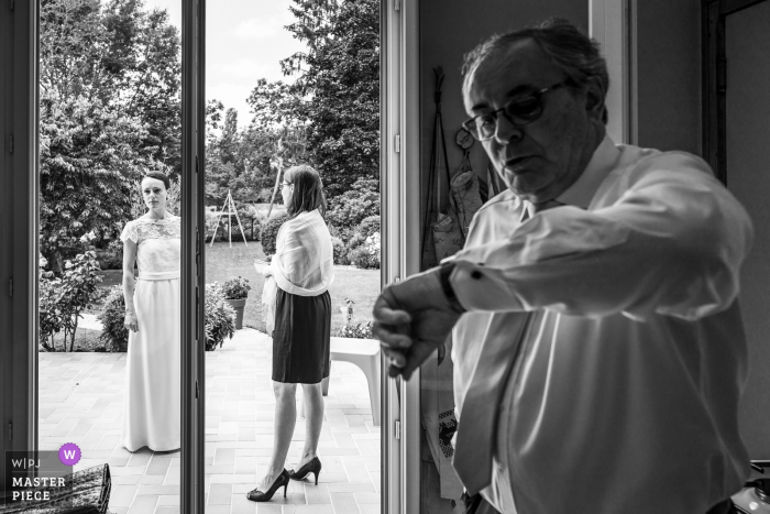 Photo by: <a href="https://www.wpja.com/contests/2019-v07/best-wedding-photographers/2506531">Henri Deroche - Orléans </a> A man checks his watch before the ceremony in Checy in this black and white wedding photo composed by an award-winning Val de Loire, France photographer.