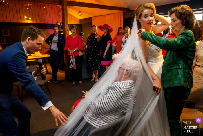 Photo by: <a href="https://www.wpja.com/contests/2019-v07/best-wedding-photographers/2506846">Indra Simons - Enschede Overijssel</a> A bride accidentally drapes her veil over a guest at her Delden - Hoeve de Haer wedding in this photo captured by an award-winning Overijssel, Netherlands photographer.