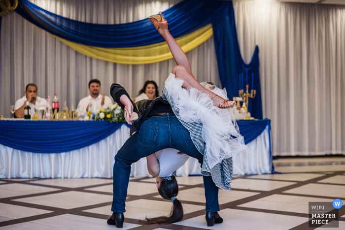 Photo by: <a href="https://www.wpja.com/contests/2019-v07/best-wedding-photographers/2507291">Ivelina Cholakova - Sofia Sofia</a> The groom flips the bride over his shoulder on the dance floor in NDK in this photo created by a Sofia, Bulgaria wedding photographer.