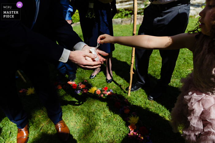 Photo by: <a href="https://www.wpja.com/contests/2019-v07/best-wedding-photographers/2508006">Sarah V. Martinez - Dover New Hampshire</a> Jackson, New Hampshire Wedding ceremony photography | The flower girl hands the groom the rings under the chuppah