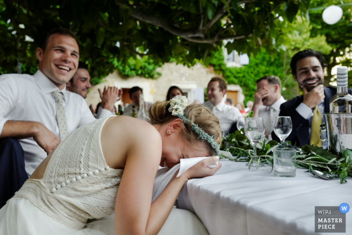 Photo by: <a href="https://www.wpja.com/contests/2019-v08/best-wedding-photographers/2512121">William Lambelet - Montpellier </a> The guests and bride cannot stop laughing during a funny speech at her Chateau du Puits es Pratx, Ginestas wedding in this award-winning photo by a Montpellier, France wedding photographer.