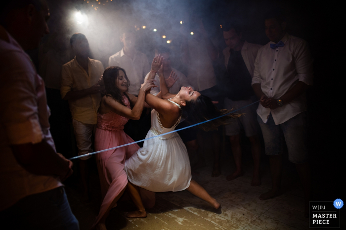 Photo by: <a href="https://www.wpja.com/contests/2019-v08/best-wedding-photographers/2514446">Bozhidar Krastev - Ruse </a> Iguana Bar, Sozopol, Bulgaria Wedding Venue Photos - The Bride and the Limbo dance on the dance floor