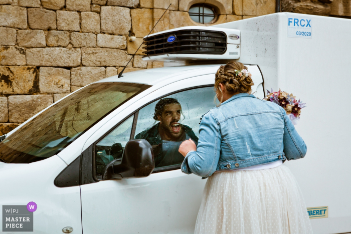 Photo by: <a href="https://www.wpja.com/contests/2019-v08/best-wedding-photographers/2518391">Lucie Mahé - Die </a> The bride looks at her friend through a car window in Le Cheylard in this wedding image composed by a Drome, Auvergne-Rhone-Alpes photographer.