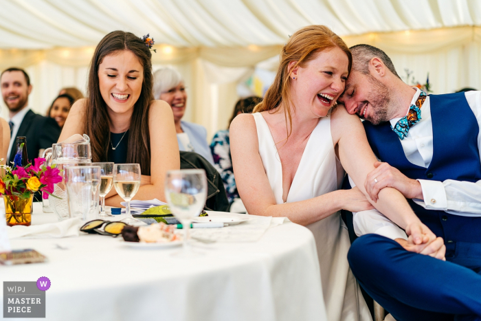 Sposo morente di imbarazzo e sposa che ride a crepapelle mentre il migliore canta un'ode a lui durante i discorsi di Perriswood, Gower, Galles