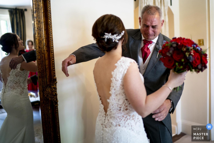 Woodhall Manor, Suffolk, UK reportagem de casamento fotografia | Pai da noiva quebra depois de ver sua filha pela primeira vez em seu vestido antes de sair para encontrar seu marido para ser.