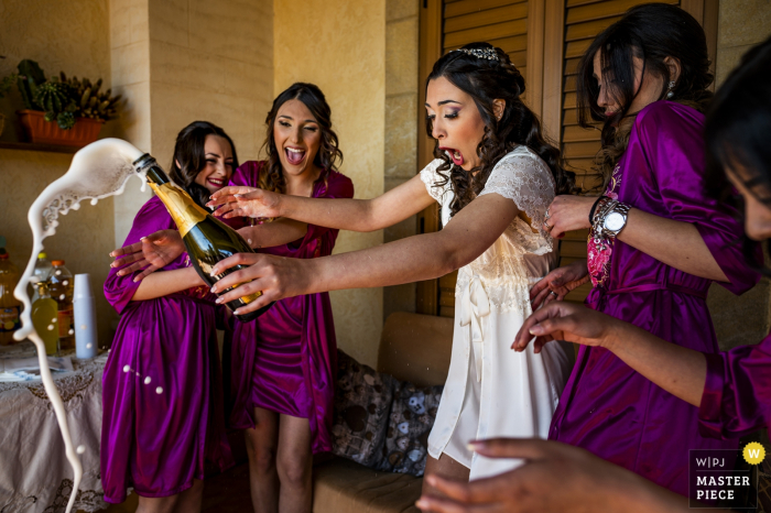 Photo by: <a href="https://www.wpja.com/contests/2019-v08/best-wedding-photographers/2518721">Pasquale Minniti - Reggio Calabria</a> The bride and her bridesmaids are shocked as the bottle of champagne pops open in this award-winning image by a Reggio Calabria, Calabria wedding photographer.