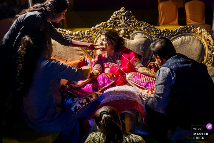 Photo by: <a href="https://www.wpja.com/contests/2019-v08/best-wedding-photographers/2518746">Pasquale Minniti - Reggio Calabria</a> The bride is surrounded by people helping her get ready in Ahmedabad in this photo by a Calabria wedding photographer.