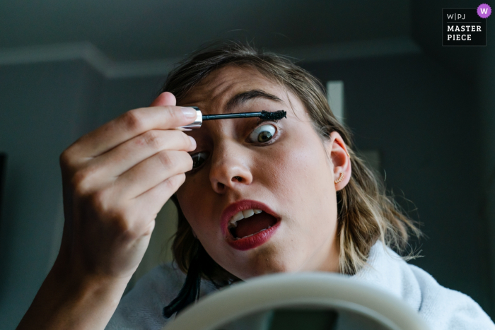 Photo by: <a href="https://www.wpja.com/contests/2019-v08/best-wedding-photographers/2520376">Simon Leclercq - Leuven Vlaams Brabant</a> The bride makes a funny face as she applies mascara at Filmfabriek Bierbeek in this image composed by a documentary-style Flanders wedding photographer.
