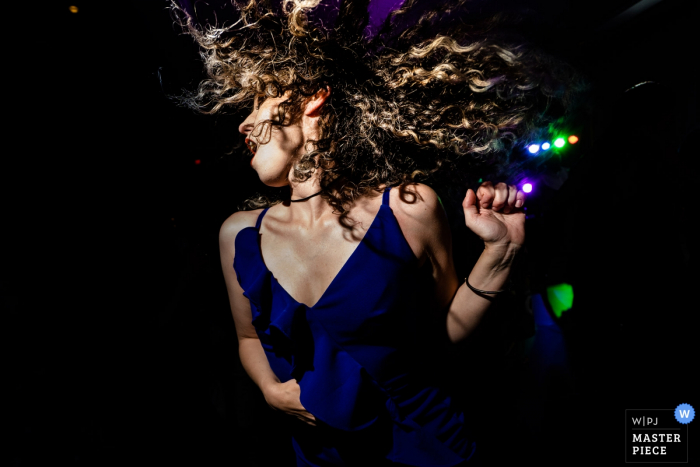 a wedding reception guest dancing under the dj lights with her hair flying Atlanta wedding reception guest dancing under the dj lights with her hair flying