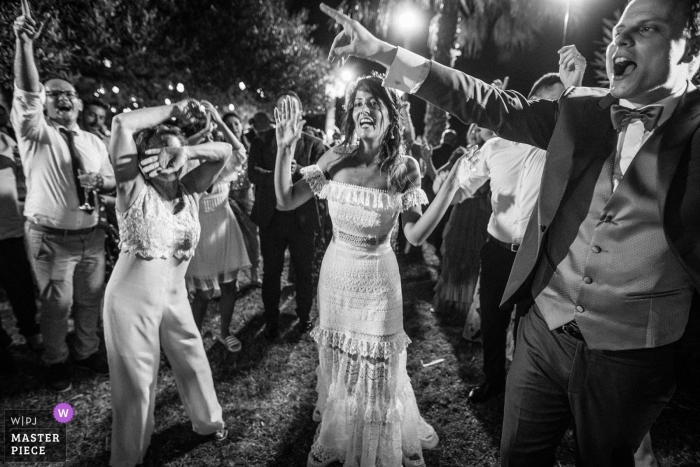 Foto von: <a href="https://www.wpja.com/contests/2019-v09/best-wedding-photographers/2526466"> Davide Di Pasquale - Caltagirone Catania </a> Taormina Schwarzweiss-Hochzeitsbild, welches das Braut- und Gasttanzen an ihrer Aufnahme gefangennimmt.