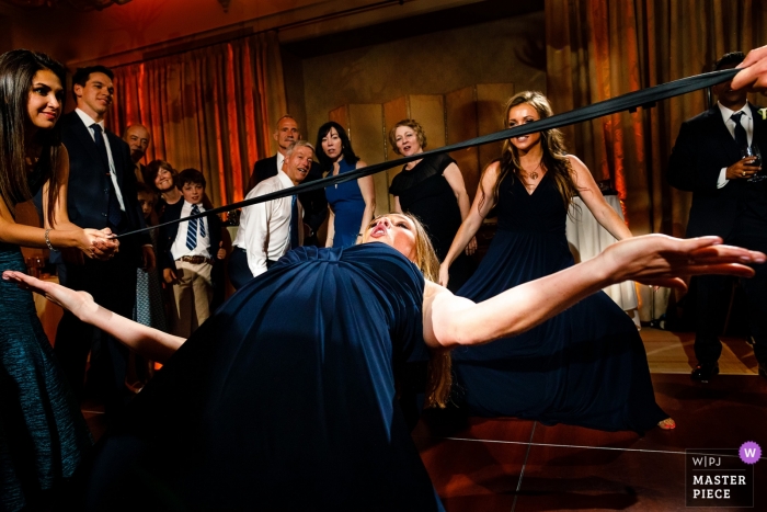 Photo by: <a href="https://www.wpja.com/contests/2019-v09/best-wedding-photographers/2528026">Stacy Gillespie - Silverthorne Colorado</a> A wedding reception photograph of a woman doing the limbo at Hotel Jerome