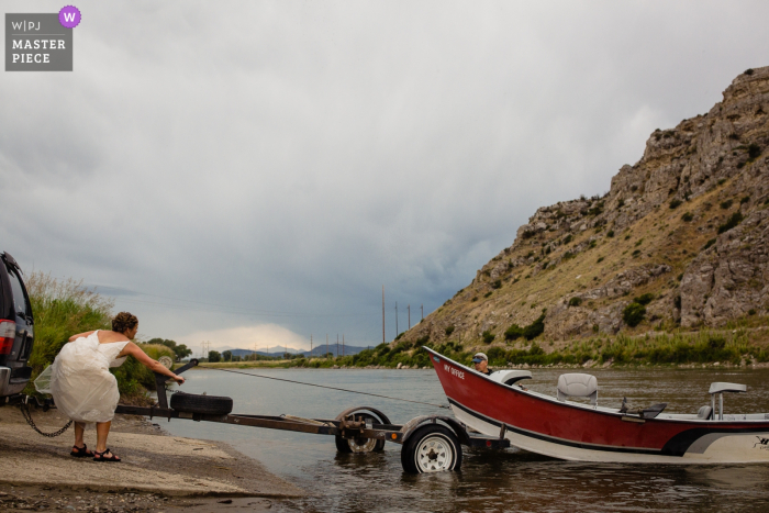 Photo: <a href="https://www.wpja.com/contests/2019-v09/best-wedding-photographers/2530676"> David Clumpner - Missoula Montana </a> Jour du mariage dans le Missouri Headwaters Park - La mariée aide à tirer un bateau à la dérive hors de la rivière après la cérémonie