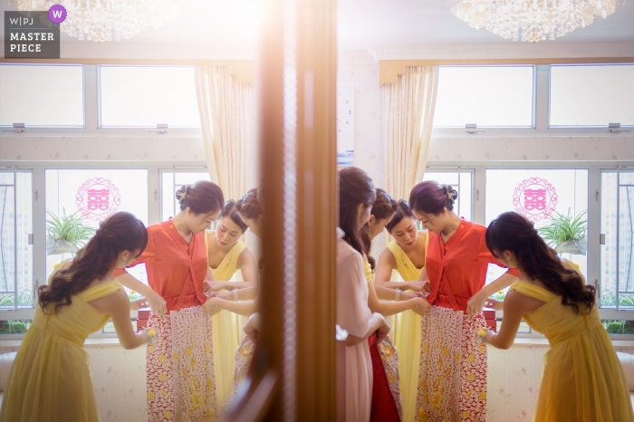 Photo by: <a href="https://www.wpja.com/contests/2019-v09/best-wedding-photographers/2530961">Rico Tsui - Central </a> Bride receives assistance in getting ready for her Hong Kong wedding.