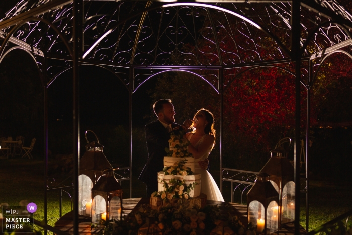 Photo by: <a href="https://www.wpja.com/contests/2019-v09/best-wedding-photographers/2532961">Massimiliano Esposito - Orvieto Terni</a> Cake cutting photography of bride and groom at Tenuta di Polline - Lago di Bracciano - Italy