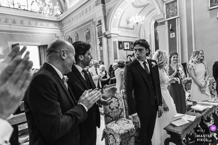 Photo by: <a href="https://www.wpja.com/contests/2019-v09/best-wedding-photographers/2534556">Patrizia Galliano - Barge Cuneo</a> Concerned groom looks to his groomsmen during the ceremony at Chiesa San Michele Arcangelo