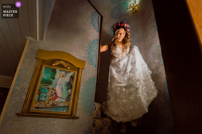 Foto von: <a href="https://www.wpja.com/contests/2019-v09/best-wedding-photographers/2534671"> Camilo Nivia - Cartagena Bolivar </a> Eine Braut, die am Hochzeitstag die Treppe zu ihrem Haus in Bogotá hinuntersteigt.