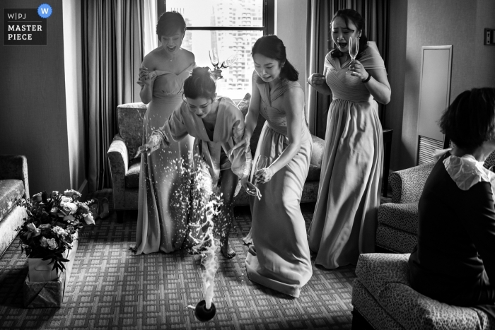 Photo by: <a href="https://www.wpja.com/contests/2019-v09/best-wedding-photographers/2535951">Cafa Liu - Richmond Hill Ontario</a> Black and white wedding photography capture of the bride dropping the champagne to the floor in her hotel room at The Arlington Estate, Canada.