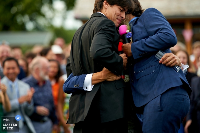 Photo by: <a href="https://www.wpja.com/contests/2019-v09/best-wedding-photographers/2536666">Martin Beddall - Horsham West Sussex</a> Clayton, UK Doucmentary Wedding Photography - Groom hugs his two best man (and spills his drink) during