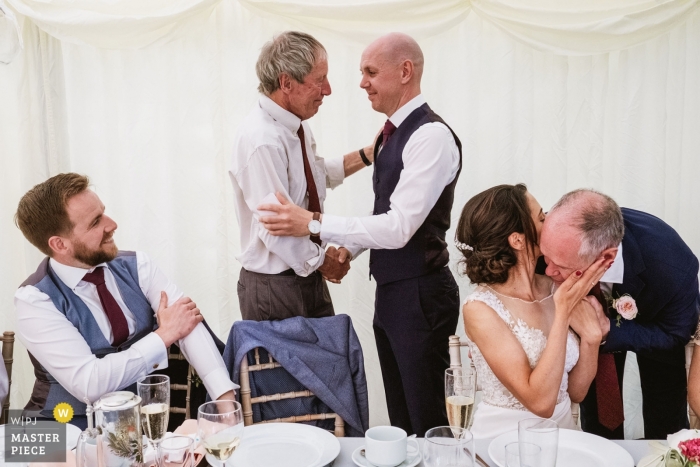 Foto von: <a href="https://www.wpja.com/contests/2019-v09/best-wedding-photographers/2537631"> Dominique Shaw - Scarborough North Yorkshire </a> Leathley Village Hall Hochzeitsort - Fotografie von Umarmungen Nach den Reden.