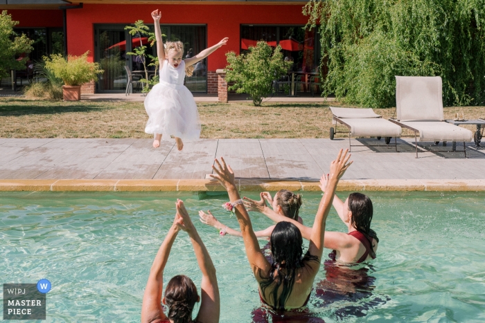 Photo by: <a href="https://www.wpja.com/contests/2019-v09/best-wedding-photographers/2537651">Sylvain Bouzat - Lyon </a> Chateau d'Eppeyssoles Wedding Venue - Photography - Young girl jumps in the swimming pool!