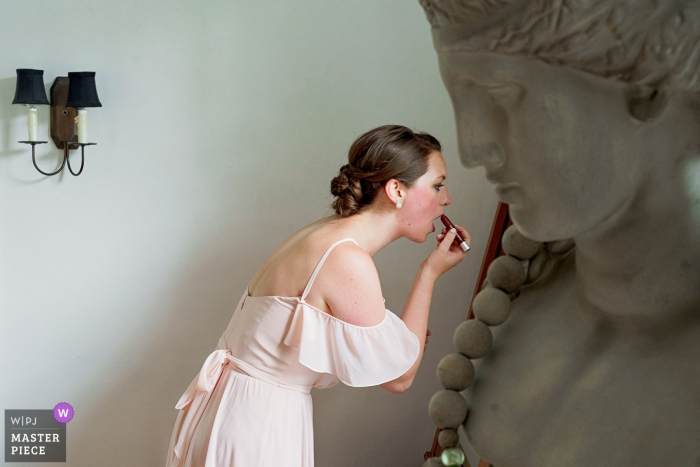 Photo by: <a href="https://www.wpja.com/contests/2019-v09/best-wedding-photographers/2538381">Alex Paul - Boston Massachusetts</a> Bridesmaid getting ready with lipstick at the White Elephant, MA
