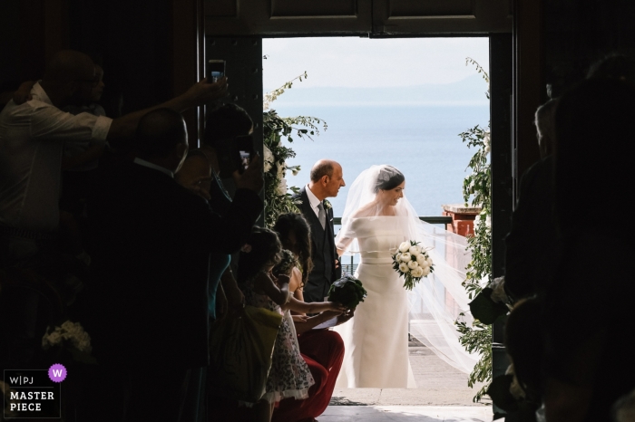 Foto von: <a href="https://www.wpja.com/contests/2019-v09/best-wedding-photographers/2538836"> Luca Salvemini - Portici Napoli </a> Vico Equense - Fotograf der Hochzeitszeremonie in Santa Maria delle Grazie - Die Braut und ihr Vater betraten die Kirche