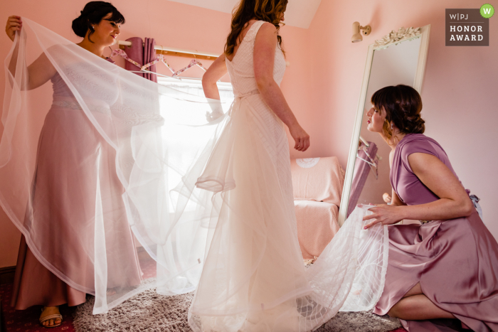 Smugglers Inn, Waterville, Kerry, Irlanda foto de reportaje de boda en el lugar - Las damas de honor rosadas visten a la novia en la habitación rosada