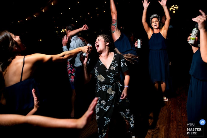 Foto von: <a href="https://www.wpja.com/contests/2019-v09/best-wedding-photographers/2539796"> Jesse La Plante - Boulder Colorado </a> Lionsgate Event Center-Fotos - Hochzeitsgast singt in ein Bierdosenmikrofon.