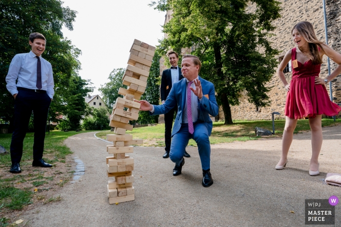 Photo by: <a href="https://www.wpja.com/contests/2019-v09/best-wedding-photographers/2540061">Tobias Löhr - Niddatal Hessen</a> Schloss Romrod Photos of Fun at the wedding reception with wooden tower of Jenga falling over