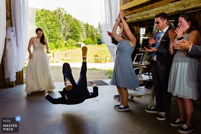 Photo by: <a href="https://www.wpja.com/contests/2019-v09/best-wedding-photographers/2541416">Sarah V. Martinez - Dover New Hampshire</a> Kitz Farm in Strafford New Hampshire Wedding Photographs - The groom does an impromptu flip into the wedding reception
