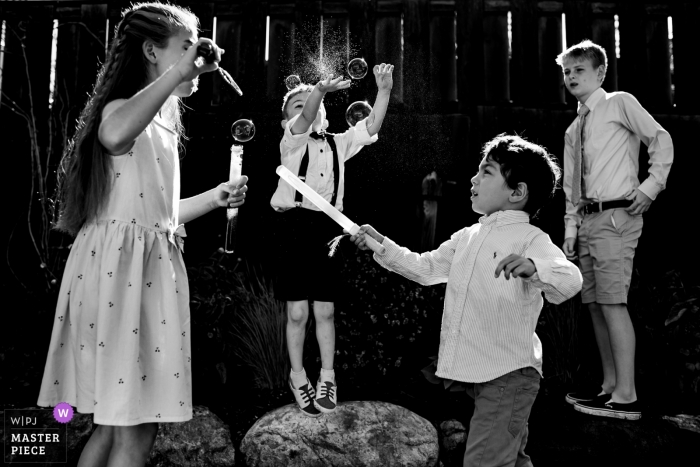 Photo by: <a href="https://www.wpja.com/contests/2019-v09/best-wedding-photographers/2541966">Jacob Hannah - Lincoln Vermont</a> Kids play with bubbles during the cocktail hour at Mountain Top Inn, Chittenden, VT