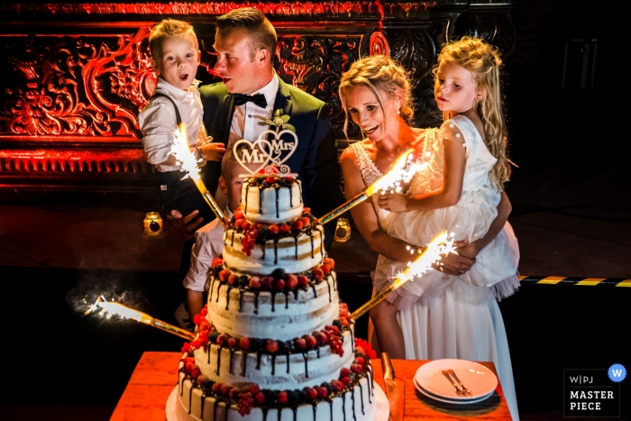 Photo by: <a href="https://www.wpja.com/contests/2019-v10/best-wedding-photographers/2543240">Philippe Swiggers - Bekkevoort </a> Kasteel van Hoen - Photo of spectacular Cake with fireworks and kids and the bride/groom.