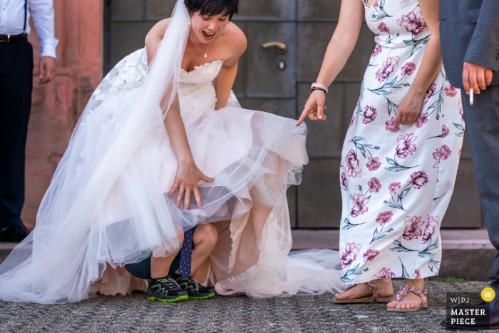 Zdjęcie: <a href="https://www.wpja.com/contests/2019-v10/best-wedding-photographers/2543394"> David Anton - Oberkirch </a> Dziecko niespodziewanie wchodzi pod suknię ślubną, zaskakując pannę młodą i wszystkich w Zell am Harmersbach.
