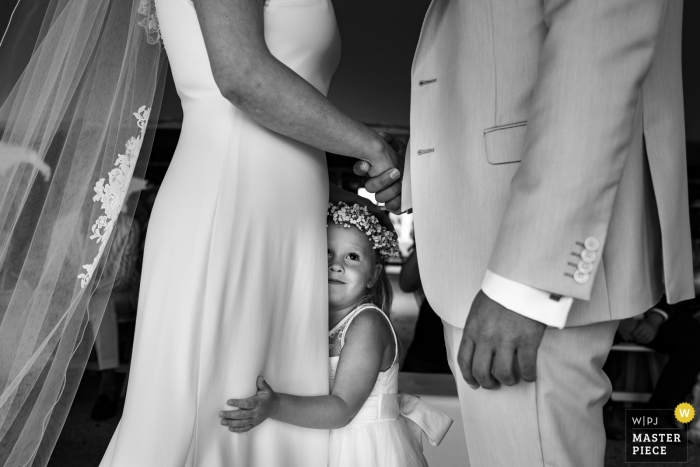 Foto von: <a href="https://www.wpja.com/contests/2019-v10/best-wedding-photographers/2543687"> Yves Schepers - Bonheiden Antwerpen </a> Die Tochter des Brautpaares umarmt ihre Mutter während der Hochzeitsversprechen im Golfclub Méan.