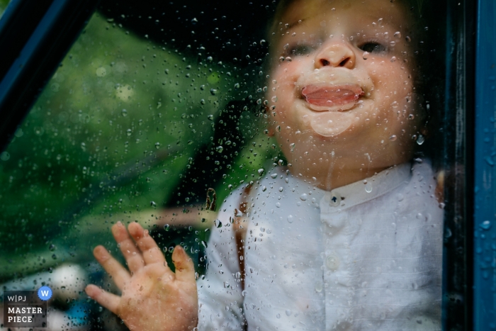 Photo by: <a href="https://www.wpja.com/contests/2019-v10/best-wedding-photographers/2543816">Leonard Walpot - Utrecht Utrecht</a> Sparrendaal kid in a car playing with the rain water on the wedding day car.
